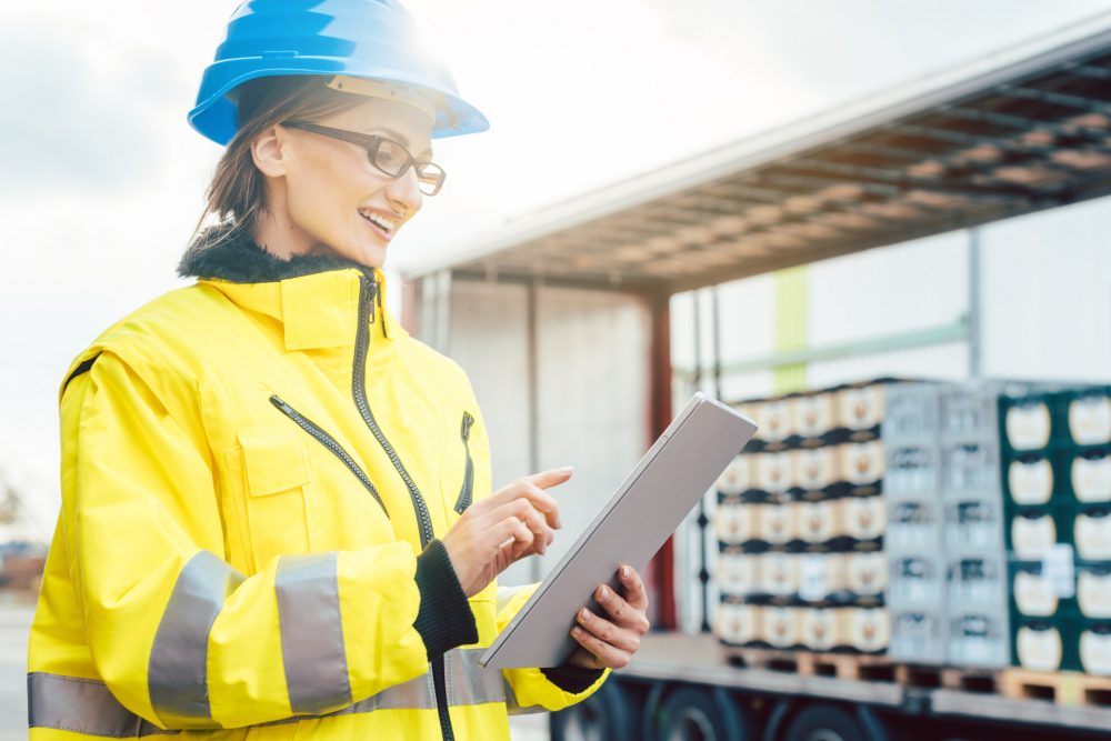 Female wearing a safety helmet and checking a tablet,